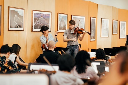 Jan Snakowski playing the viola in front of an orchestra